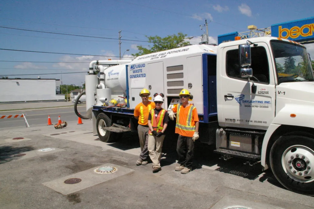 Geo-Daylighting vacuum-excavation truck with three crew members in high-visibility gear