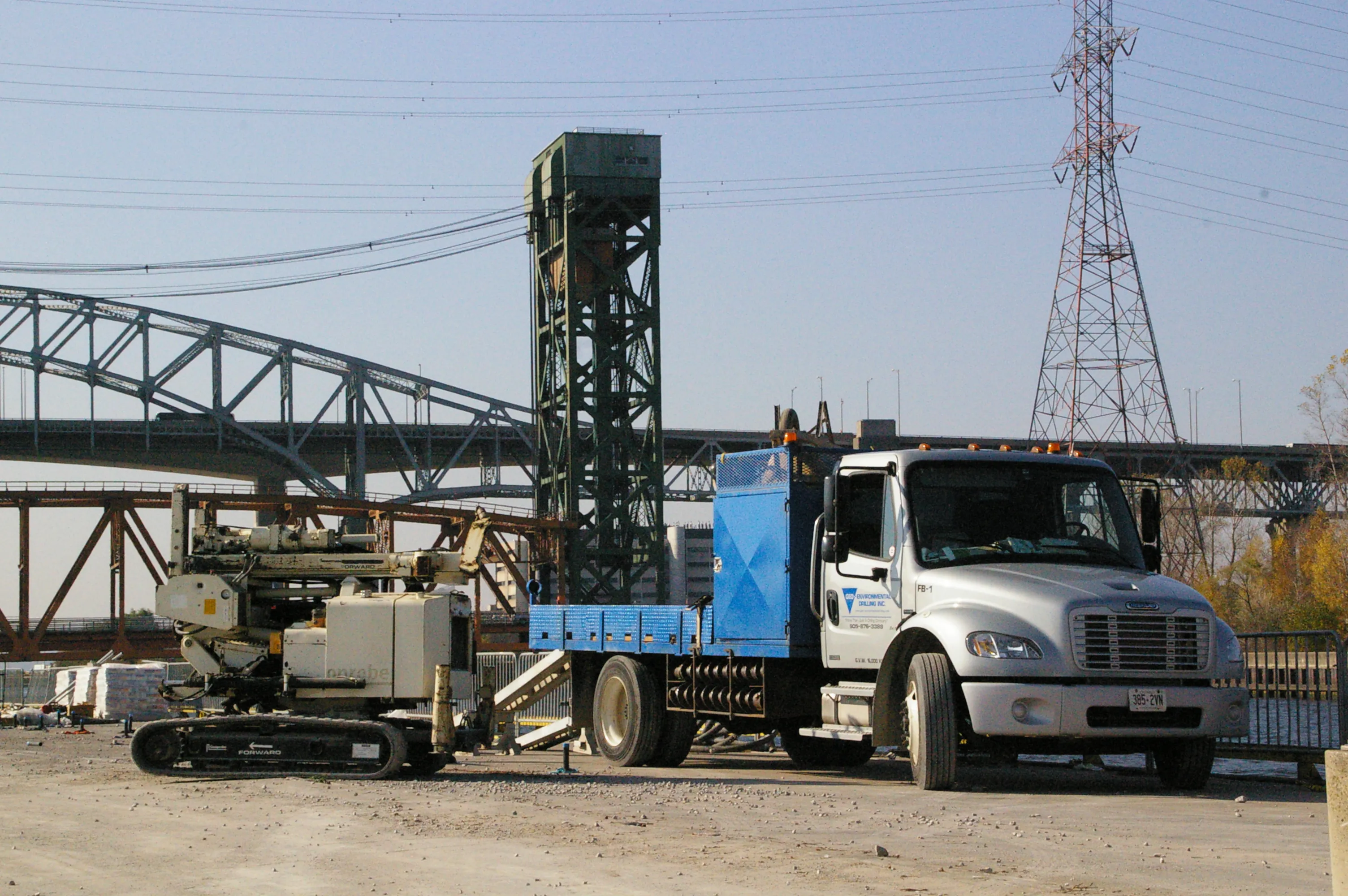 Drill rig and support truck working at Hamilton Bay, with the lift bridge behind